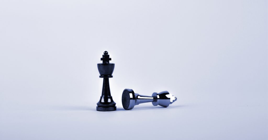 Symbolbild für Intent-Marketing: zwei Schachfiguren, von denen eine steht und eine liegt